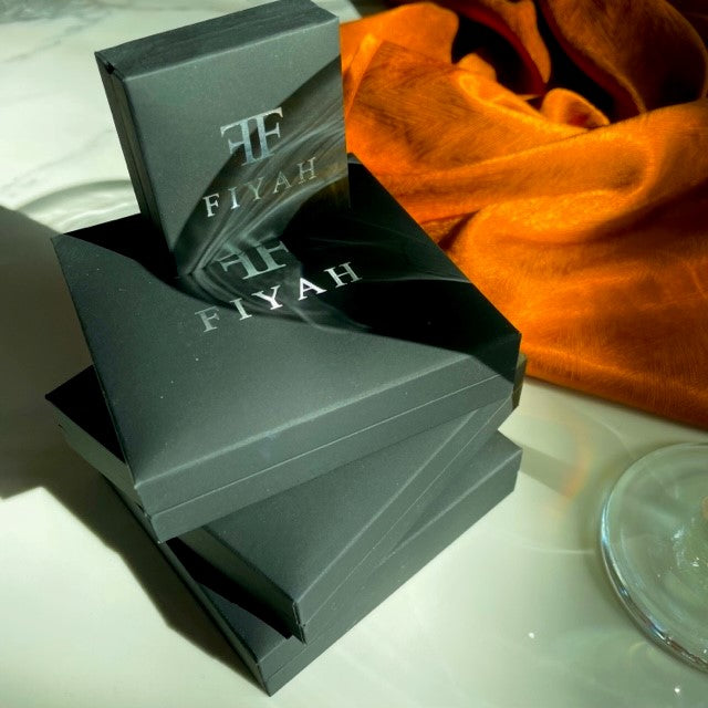 A close up of three Luxury FIYAH necklace gift boxes, with a Luxury FIYAH ring gift box on top