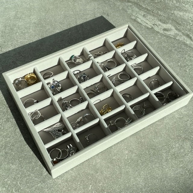 An image of a grey jewellery tray organiser with a selection of FIYAH silver jewellery